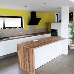 Un bel espace de vie, rehausser par un plan de travail en bois au centre de la pièce. plan de travail en bois