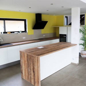 Un bel espace de vie, rehausser par un plan de travail en bois au centre de la pièce. plan de travail en bois