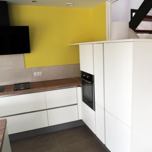 De l'électroménager noir pour s'accorder aux blanc des façades. plan de travail en bois