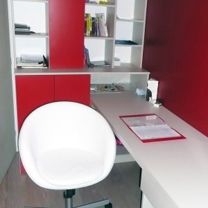 Un bureau blanc accompagné d'une grande étagère rouge. chambres d'enfants