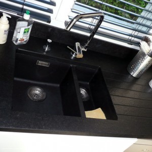 Zoom sur l'évier en granit noir, effet minéral. cuisine sans poignées