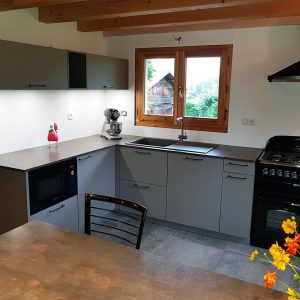 Une cuisine avec une implantation en L et un îlot en guise de table pour déjeuner.