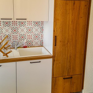 Une grande armoire en bois pour ranger tous les accessoires de cuisine.